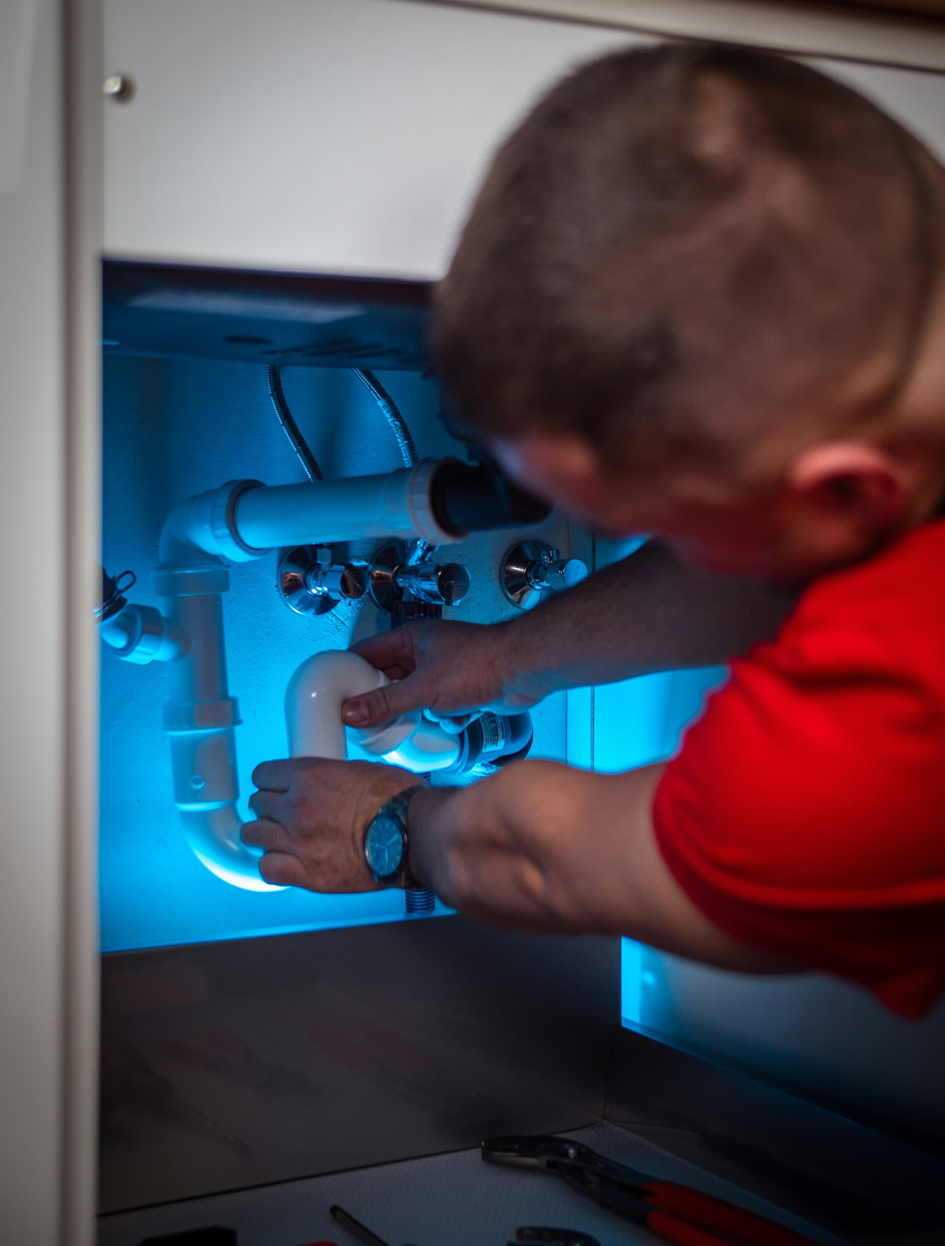Plumber working beneath a sink